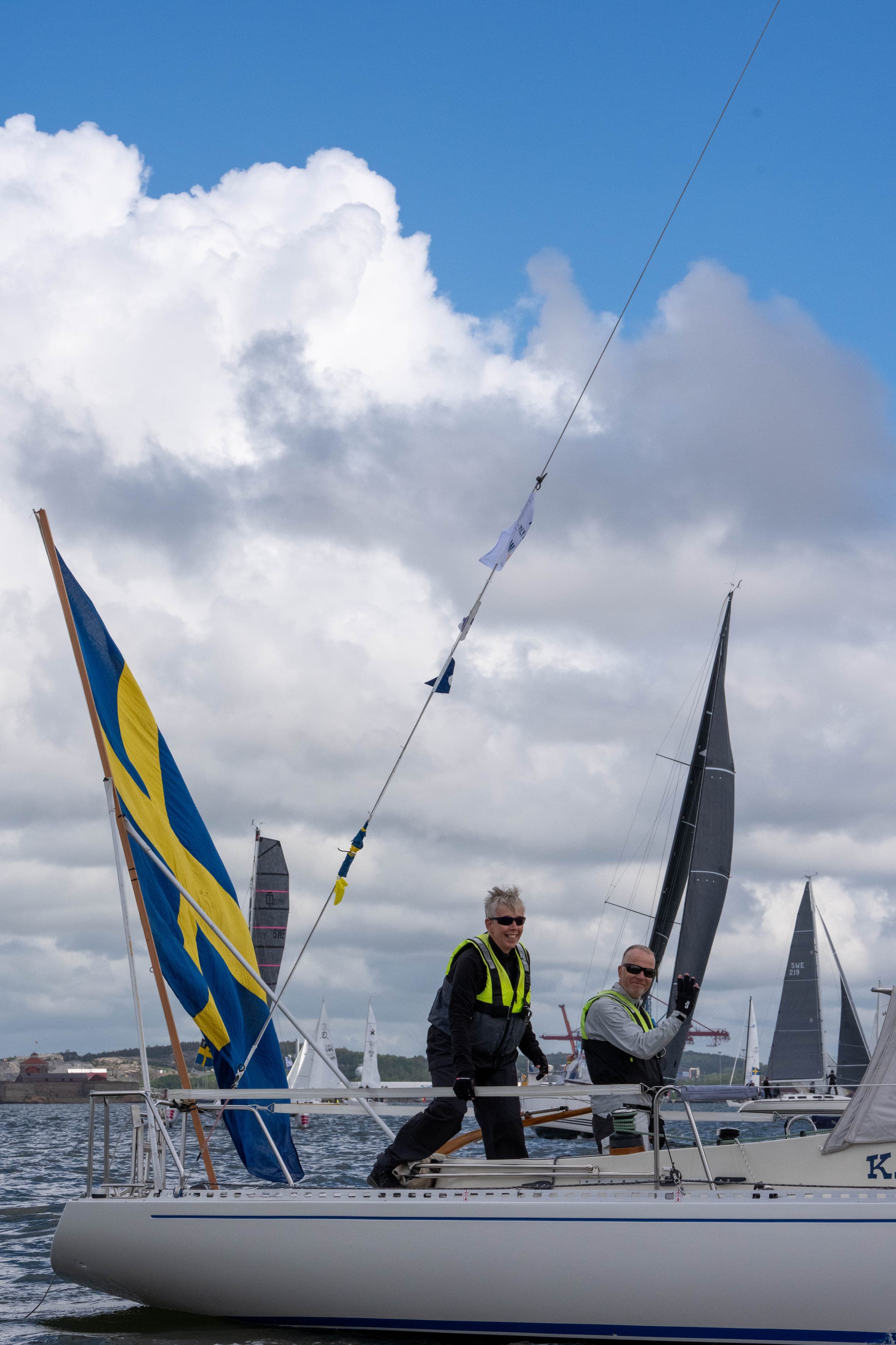 Svensk flagga som fladdrar mot masttoppen